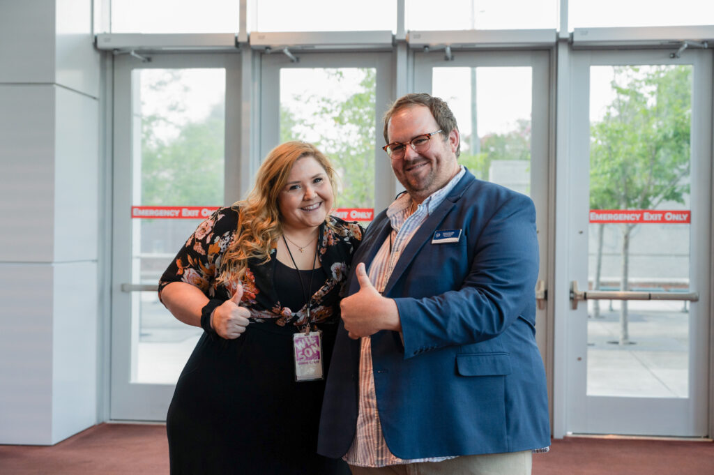 Two Wilson Theater staff, a man and a woman, smiling and giving a thumbs up.